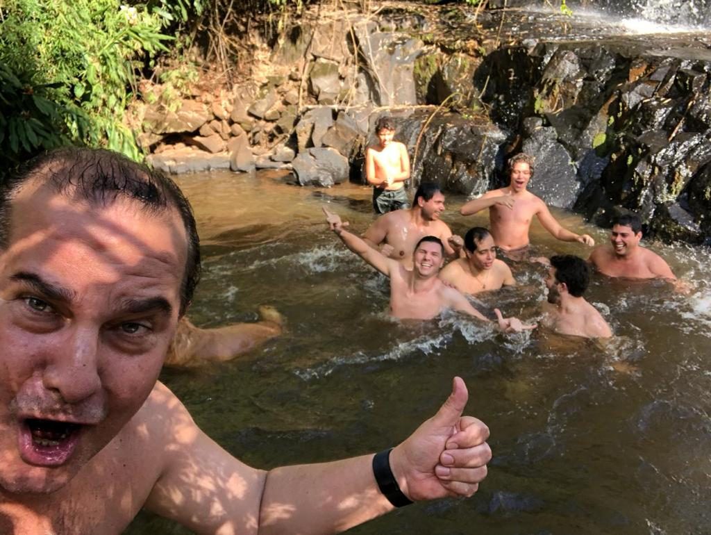Amigos se banhando numa piscina natural de cachoeira